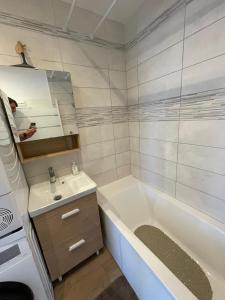 a white bathroom with a tub and a sink at Appartement vue mer situé 148 rue Carnot à Wimereux - 4 pers in Wimereux
