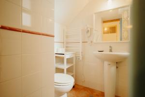 un bagno bianco con un water e un lavandino di Casa da avó Bia a Faro Altre 65 foto