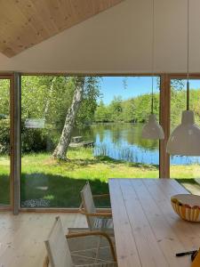 een eetkamer met uitzicht op een meer bij Architect-Designed House Close To Hornbæk in Tikøb