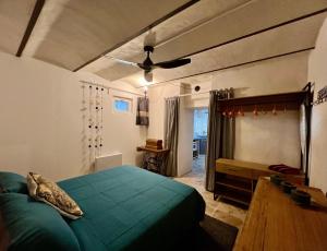 a bedroom with a green bed and a ceiling fan at L'Ecrin de Mérindol in Mérindol +50 photos
