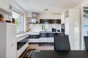 a kitchen with white cabinets and black countertops at Haus Lerchenweg B in Bad Wildungen