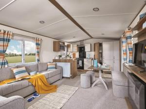 a living room with a couch and a kitchen at Heather View Leisure Park - Ivy Caravan 5 in Stanhope