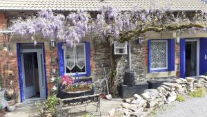 a house with purple wisterias hanging from a building at Bucolique Studette in Malemort-sur-Corrèze