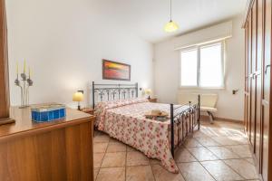 Un dormitorio con una cama y un escritorio y una ventana. en Villa Aurelio, en Capilungo