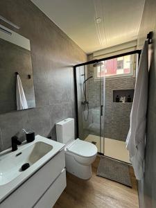 a bathroom with a toilet and a sink and a shower at Apartamento Costa Quebrada in Liencres +17 photos