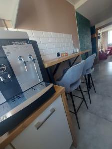Una habitación con una computadora portátil sobre un mostrador con sillas. en Apartament Dziesiątka, en Bolesławiec