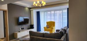 a living room with a couch and a yellow chair at Ella Homes in Nairobi