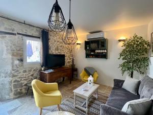 a living room with a couch and a tv at L'Ecrin de Mérindol in Mérindol