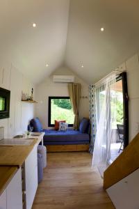 ein Wohnzimmer mit einem blauen Sofa und einem Fenster in der Unterkunft La Tiny House des Montagnes in Verrens-Arvey + 32 Fotos