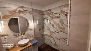 Un baño con lavabo y ducha con espejo. en Apartment Zamkowa Park, en Węgorzewo 54 fotos más