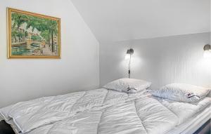 a white bed with pillows and a picture on the wall at 3 Bedroom Amazing Home In Højby in Højby +16 photos