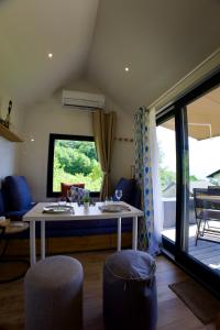 ein Wohnzimmer mit einem weißen Tisch und Stühlen in der Unterkunft La Tiny House des Montagnes in Verrens-Arvey