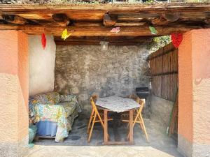 a room with a table and a bed and a table and chairs at La casa con giardino, vicino al ruscello segreto in Borzonasca