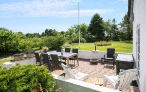 a patio with a table and chairs on a brick patio at Nice Home In Farsø With Wifi in Farsø