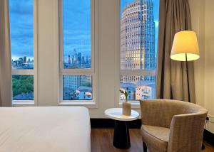a hotel room with a bed and a table and chair at H10 London Waterloo in London
