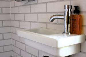 a white bathroom sink with a soap dispenser on it at Bell Tent Village Parks in Nottingham +180 photos