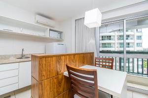 eine Küche mit einem weißen Tisch und einem Fenster in der Unterkunft Fusion Hotel em Brasília15967 in Brasilia