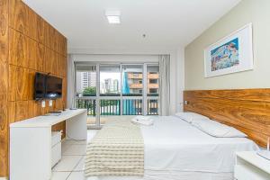 ein Schlafzimmer mit Bett, Schreibtisch und Fernseher in der Unterkunft Fusion Hotel em Brasília15967 in Brasilia