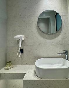 a bathroom with a white sink and a mirror at Yria Hotel in Zakynthos Town