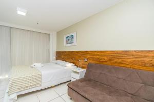 ein Schlafzimmer mit einem Bett und einer Couch in der Unterkunft Fusion Hotel em Brasília15967 in Brasilia + 31 Fotos
