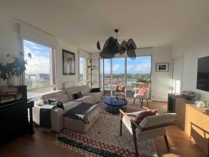 a living room with a couch and a large window at Le Belvédère - Appartement de standing, 2 chambres et parking in Nantes