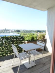 a table and two chairs on a balcony at Le Belvédère - Appartement de standing, 2 chambres et parking in Nantes