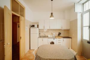 una cucina con un tavolo e un frigorifero bianco di Casa da avó Bia a Faro