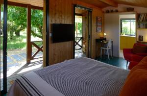 a bedroom with a bed and a flat screen tv at Les Piégonnaises - Deux luxueuses roulottes et la cabane en Drôme Provençale in Piégon