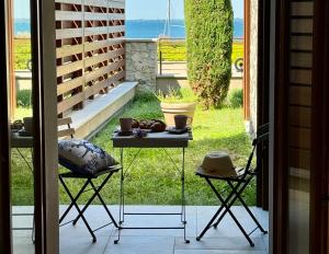 einen Tisch und zwei Stühle auf einer Terrasse in der Unterkunft Portopiccolo Apartments - Giardino vista castello in Portopiccolo Sistiana + 13 Fotos