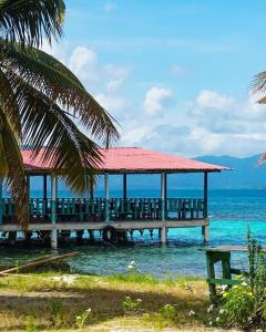 a pier with a red roof on the water at Romantic Cabin on Diablo Island San Blas in Panama City