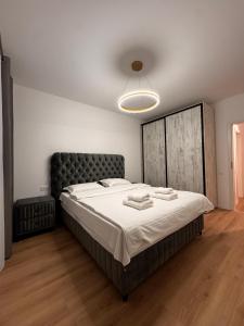 una camera da letto con un letto grande con testiera nera di MOOS Aparthotel Qualis a Braşov
