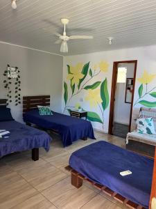 布希奥斯Arara Pousada Búzios的一间有两张床的房间，墙上挂着一幅画