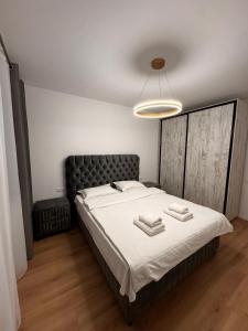 una camera da letto con un letto con due asciugamani sopra di MOOS Aparthotel Qualis a Braşov Altre 4 foto