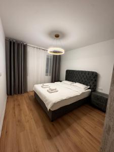 una camera da letto con un letto grande in una stanza di MOOS Aparthotel Qualis a Braşov