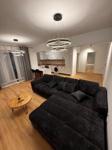 un soggiorno con un divano nero e un tavolo di MOOS Aparthotel Qualis a Braşov