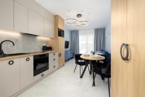 een keuken met een tafel en een eetkamer bij Apartamenty Baltic Marina in Międzywodzie