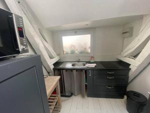 a small kitchen with a sink and a window at Cabine du Capitaine 5 in Fécamp