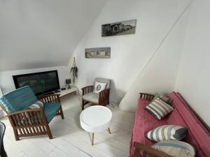 a living room with a couch and a tv at Cabine du Capitaine 5 in Fécamp +1 photo