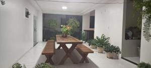 a wooden table in a room with potted plants at Casa completa para COP30 in Castanhal