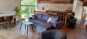una sala de estar con un sofá y una mesa en La Sauvagine vue mer, en La Vieille Perrotine