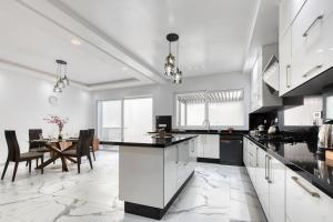 a kitchen with white cabinets and a dining room with a table at La Villa Del Mar in Agadir