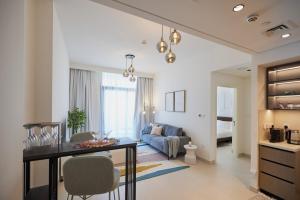 a living room with a table and a couch at Stylish 1BR Warm & Curated Interiors in Dubai +35 photos