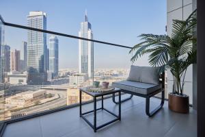 a chair on a balcony with a view of the city at Stylish 1BR Warm & Curated Interiors in Dubai