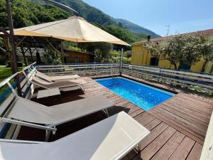 a swimming pool with two chairs and an umbrella at Casa Bruna Tettoia in Pimonte