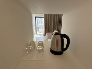 a coffee pot and two wine glasses sitting on a counter at Phoenix Coastal Heaven in Loutro
