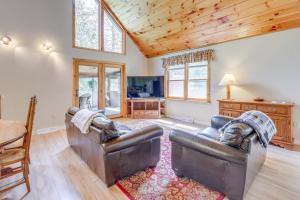 a living room with two leather couches and a table at Peaceful Family Cabin on Schroon River! in Warrensburg