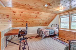 a bedroom with a desk and a bed in a cabin at Peaceful Family Cabin on Schroon River! in Warrensburg