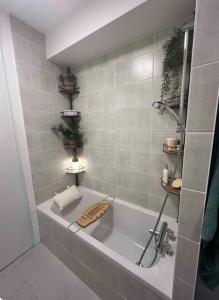 a bathroom with a bath tub with plants on the wall at Le Belvédère - Appartement de standing, 2 chambres et parking in Nantes