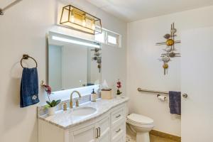 a bathroom with a sink and a toilet and a mirror at 1 Mi to Rabobank Arena Home with Gazebo! in Bakersfield +27 photos