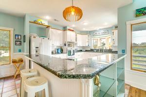 a kitchen with white cabinets and a large island at Hot Tub and Bay Views Outer Banks Home in Kill Devil Hills